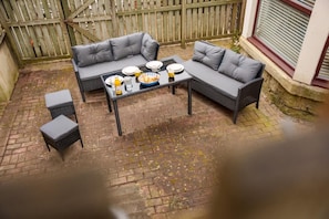 Un patio con un juego de sofá, una mesa y una mesita.