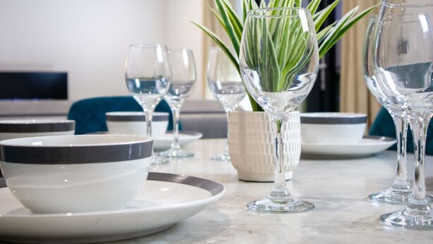 A dining table with clear glassware, a potted plant, and a bowl. - Brighton Penthouse Apartment Near Beach & Kemptown (Brighton)