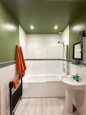 A bathroom with a bathtub, a sink, and a shower. - Private 2-bed Duplex Near Headingly w Parking (Leeds)