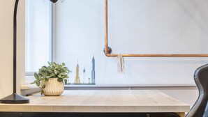 A desk with a lamp, a potted plant, and a cityscape poster on the wall. - Central Leeds Apartment by Station - Sleeps 7 (Leeds)