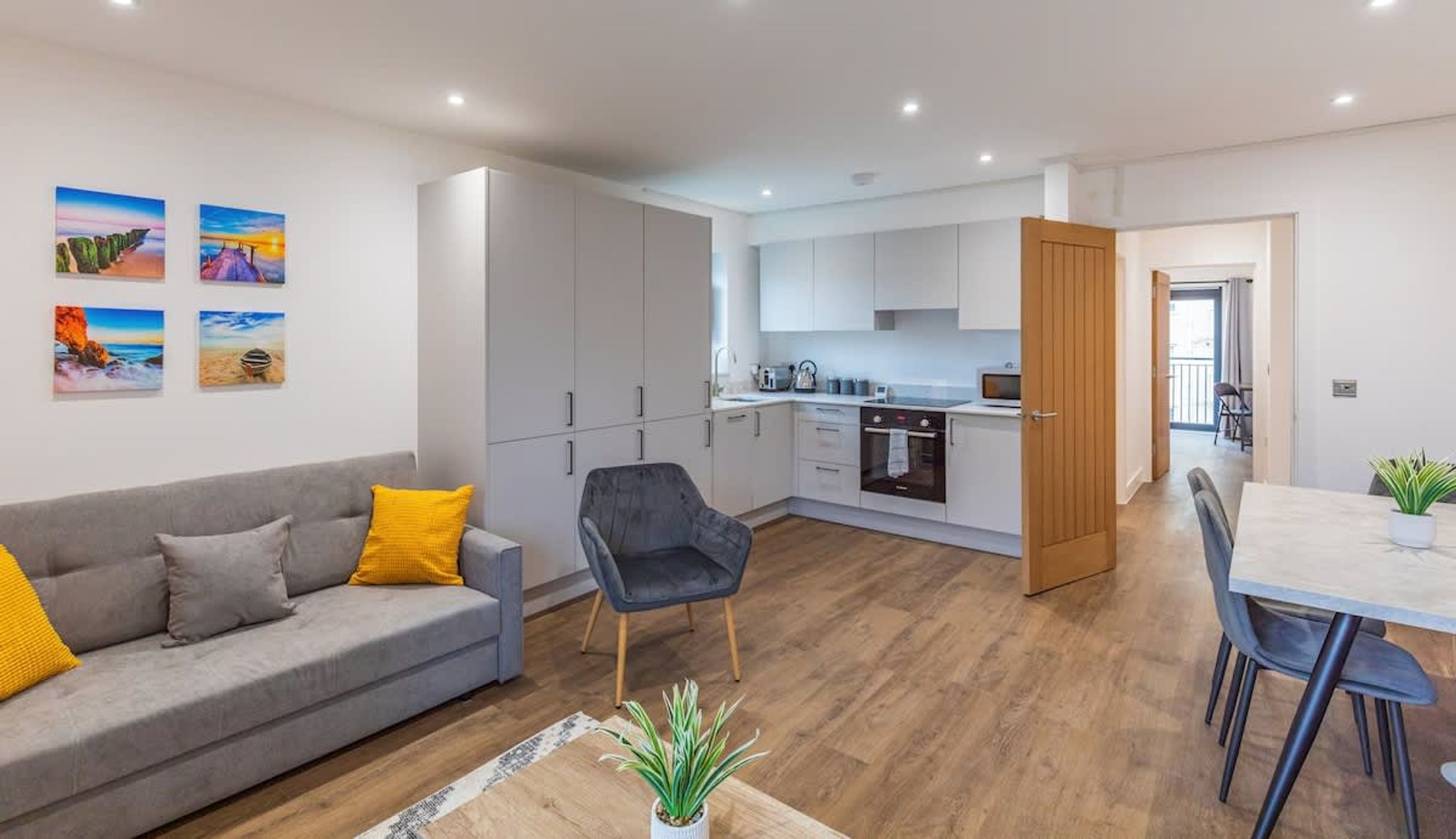 Un apartamento moderno con sala de estar, comedor, cocina y balcón.