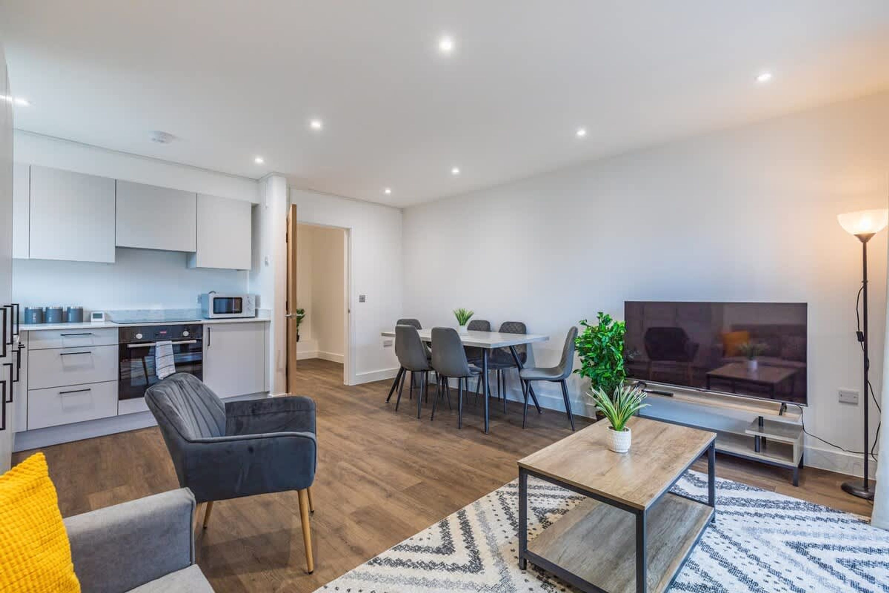 Ein modernes Apartment mit Küche, Essbereich und Wohnzimmer.