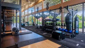 A gym with weightlifting equipment, exercise balls, and a punching bag. - EASY TIME VILLA by MARALEINA (Koh Samui)