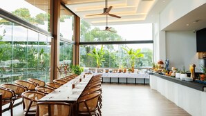 A modern dining area with a long table, wicker chairs, and a ceiling fan. - EASY TIME VILLA by MARALEINA (Koh Samui)