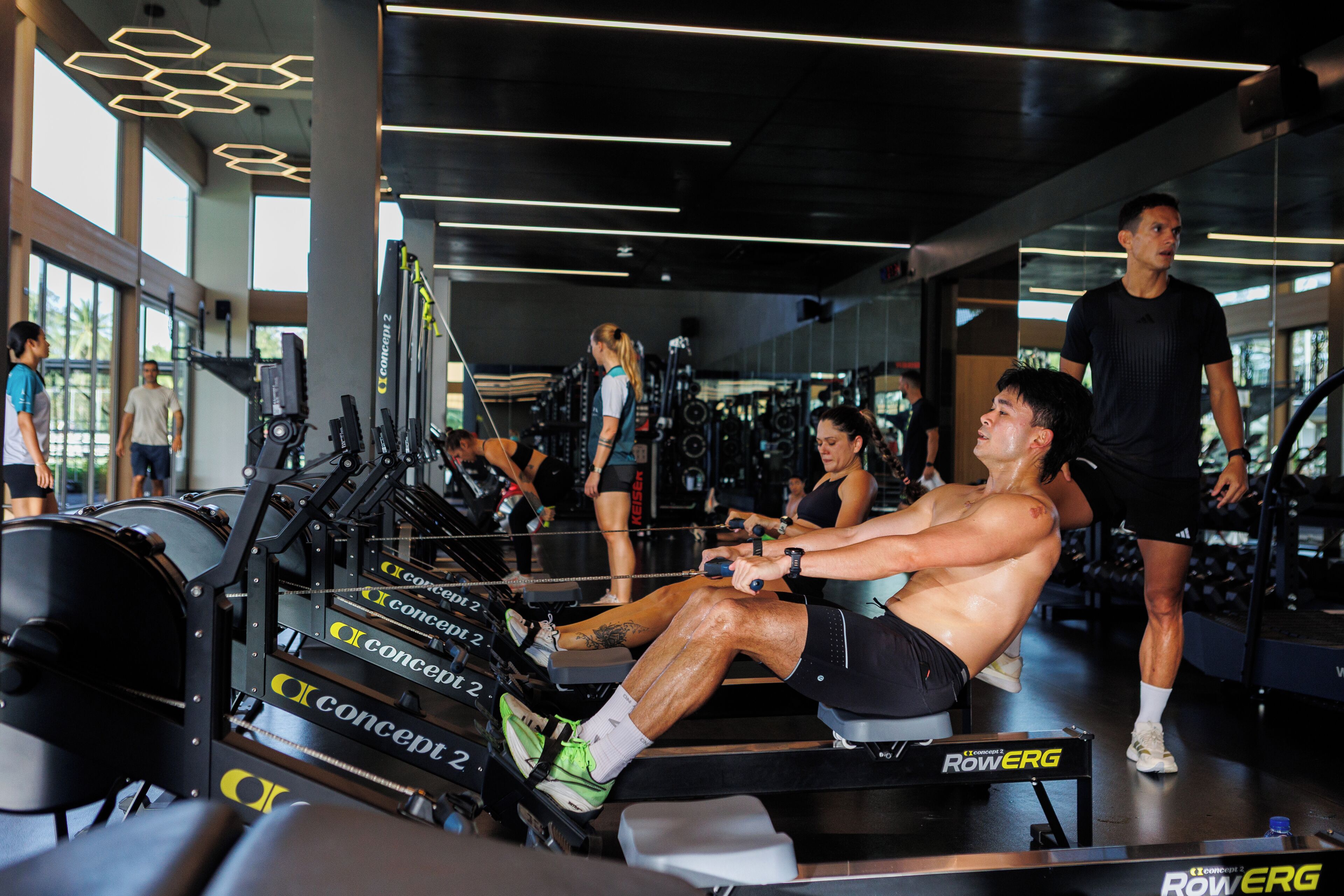 A gym with exercise equipment, large windows, and a modern interior design.