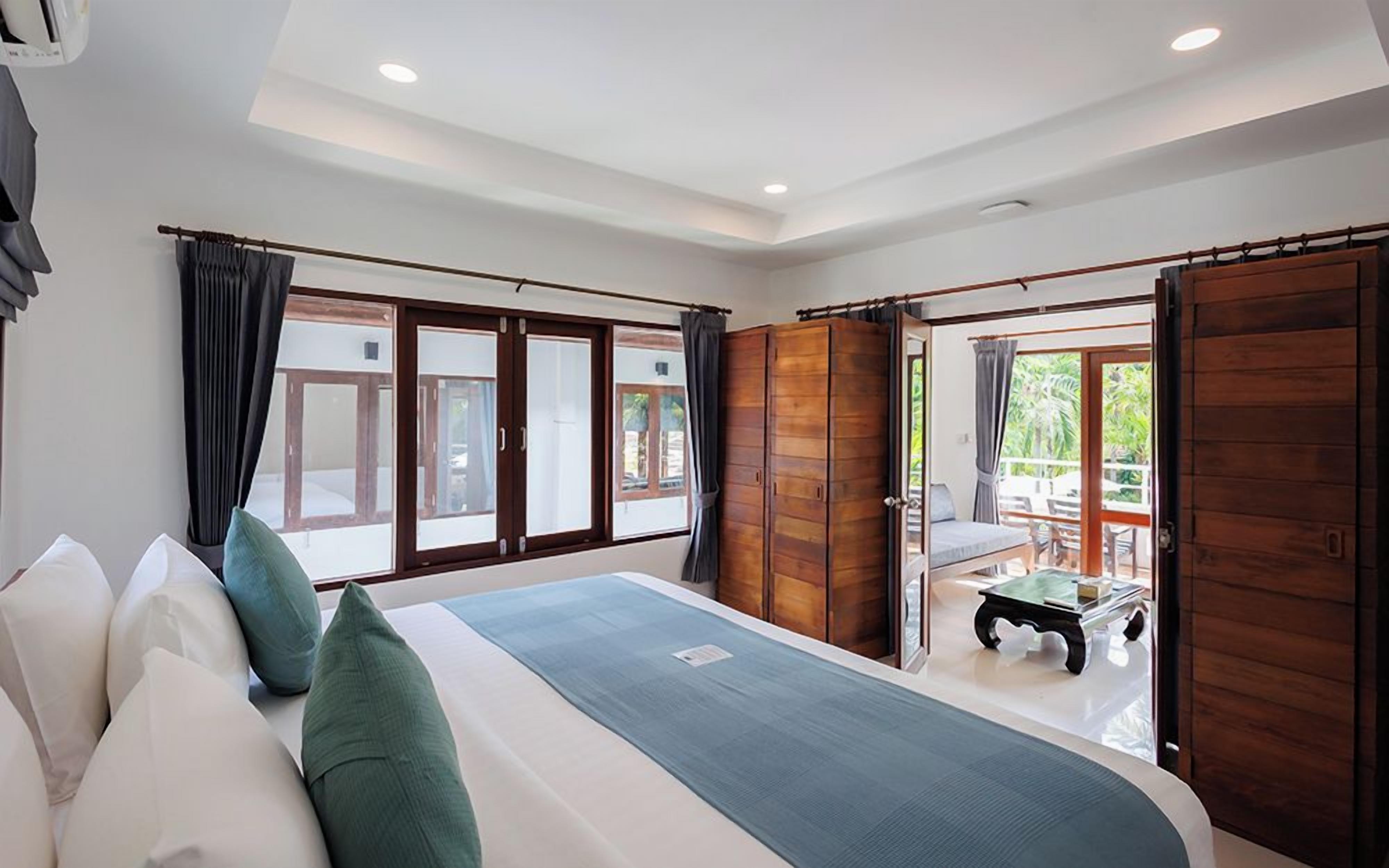 Un dormitorio con cama, cortinas y vistas al exterior.