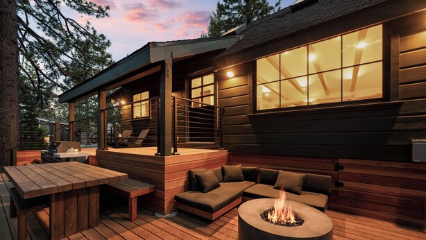 A wooden deck with a fire pit, outdoor seating, and a grill area. - Aurora Hygge - Lakefront Luxury Home with Sauna, Hot Tub, Lake Views (Big Bear Lake)