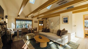 A modern living room with a sofa, coffee table, and a fireplace. - Aurora Hygge - Lakefront Luxury Home with Sauna, Hot Tub, Lake Views (Big Bear Lake)