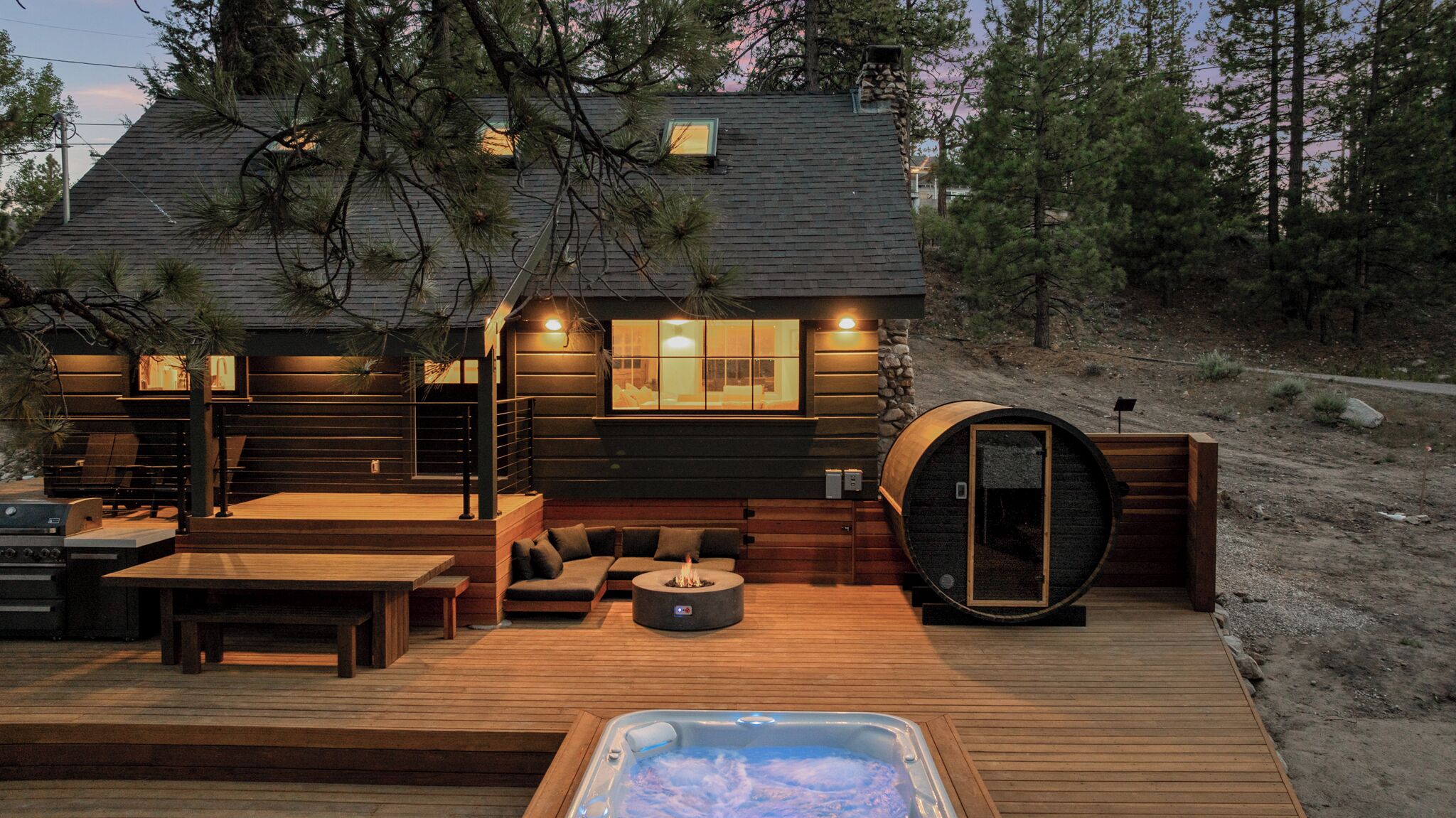Eine Hütte mit Terrasse, Whirlpool und Sauna.