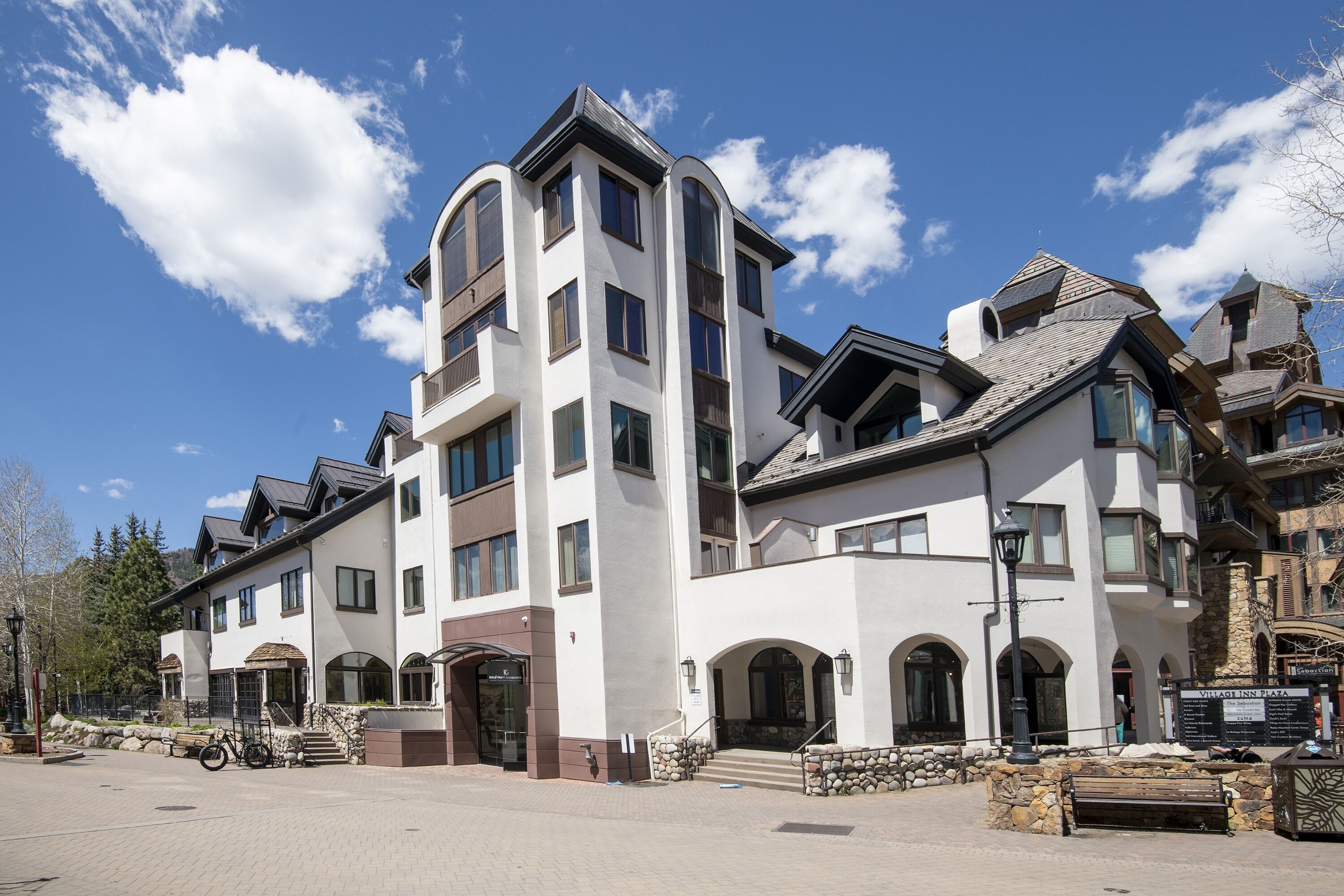 Un hotel de varios pisos con fachada de piedra, ventanas grandes y una entrada destacada.