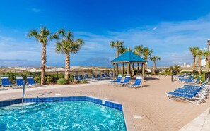 A pool area with lounge chairs, a gazebo, and palm trees. - Phoenix East 804 2 Bedroom Condo (Orange Beach)
