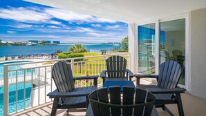 Ein Balkon mit Blick auf ein Gewässer, einen Pool und eine Brücke in der Ferne.