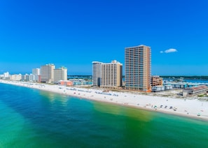 A coastal cityscape with high-rise buildings, a beach, and clear blue skies. - Phoenix Gulf Shores 1901 4 Bedroom Condo (Gulf Shores)