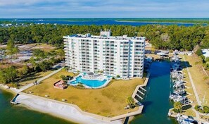 A high-rise hotel with a swimming pool and marina. - Back Bay 207 2 Bedroom Condo (Orange Beach)
