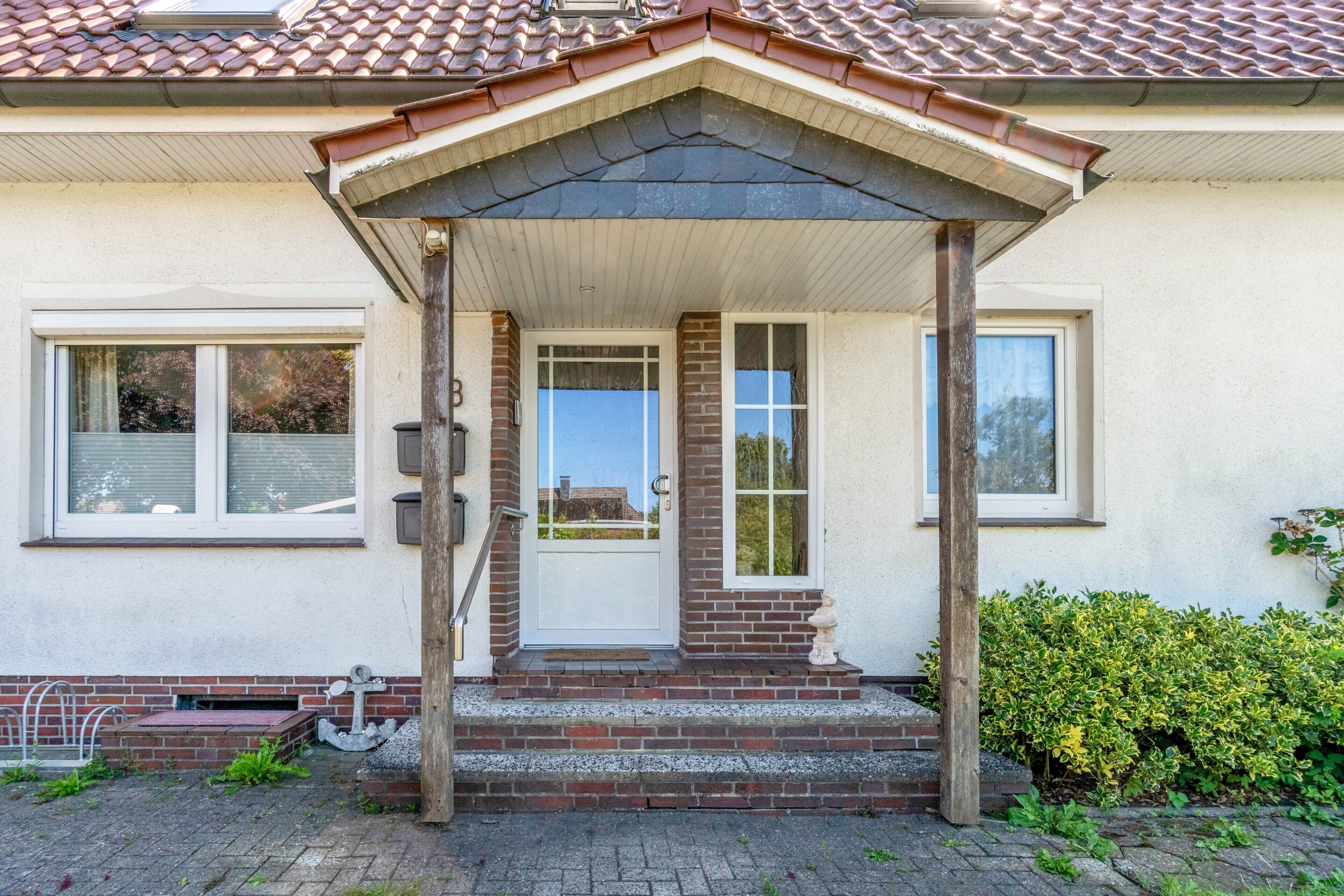 Et hus med veranda, dør og vindue.