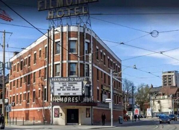 A brick building with a marquee sign advertising a theater and a hotel. - Filmores Hotel (Toronto)