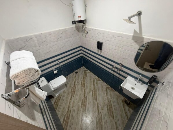 A bathroom with a toilet, sink, towel rack, and a mirror. - A ONE RESIDENCY (Gurugram)