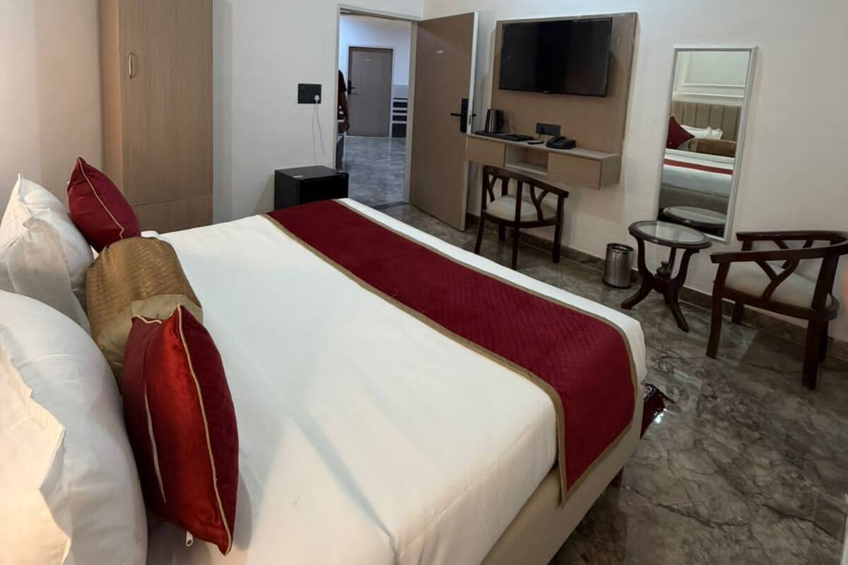 Une chambre d’hôtel équipée d’un lit, d’un bureau, d’une chaise, d’une t élévision et d’un ventilateur de plafond.