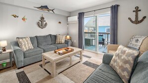 A living room with a sofa, coffee table, and a view of the outside. - Great Location for Sunday Fireworks and Easy Walk to the Beach! Has a Pool! (Ocean City)