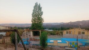 Ein Wohngebiet mit Schwimmbad, einer Holzkonstruktion und Blick auf Berge.