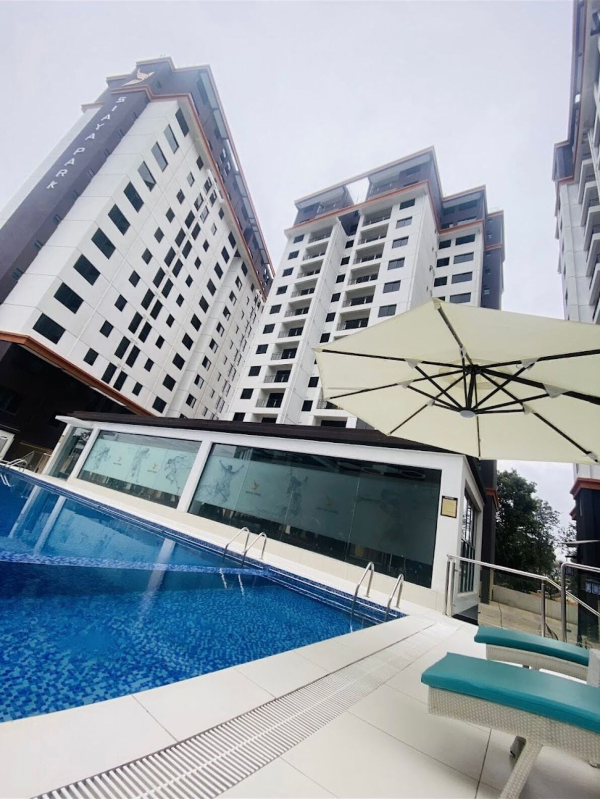 A modern building with a swimming pool, large windows, and a unique architectural design.