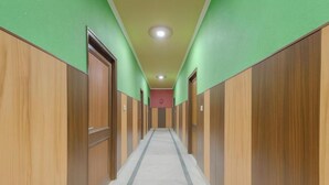 A long, narrow hallway with wooden paneling on both sides and a tiled floor. - Hotel Shiri Krishna  (Mathura)
