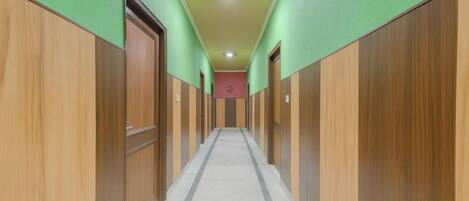 A long, narrow hallway with wooden paneling on both sides and a tiled floor.