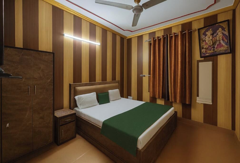 A bedroom with a bed, nightstand, wardrobe, and a ceiling fan.