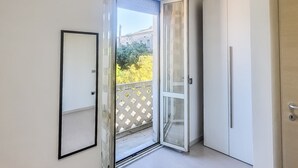 A room with a sliding glass door leading to an outdoor balcony with a patterned fence. - Dolia Court - Dolianova (Dolianova)