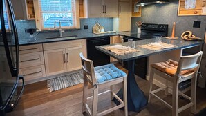 Una cocina moderna con armarios de madera, una isla central y un horno empotrado.