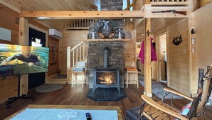 Un interior de madera con chimenea, televisor y trineo.
