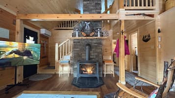 Un intérieur en bois avec une cheminée, un téléviseur et une luge.