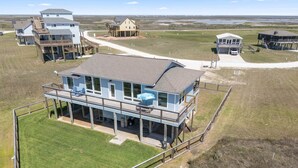 A coastal house with a large deck, multiple levels, and a view of the beach. - Driftwood Beach House: Your Perfect Getaway in Matagorda (Matagorda)