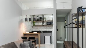 A modern kitchen with a built-in microwave, a small refrigerator, and a coffee machine. - Largo do Machado Metrô Aterro do Flamengo (Rio de Janeiro)