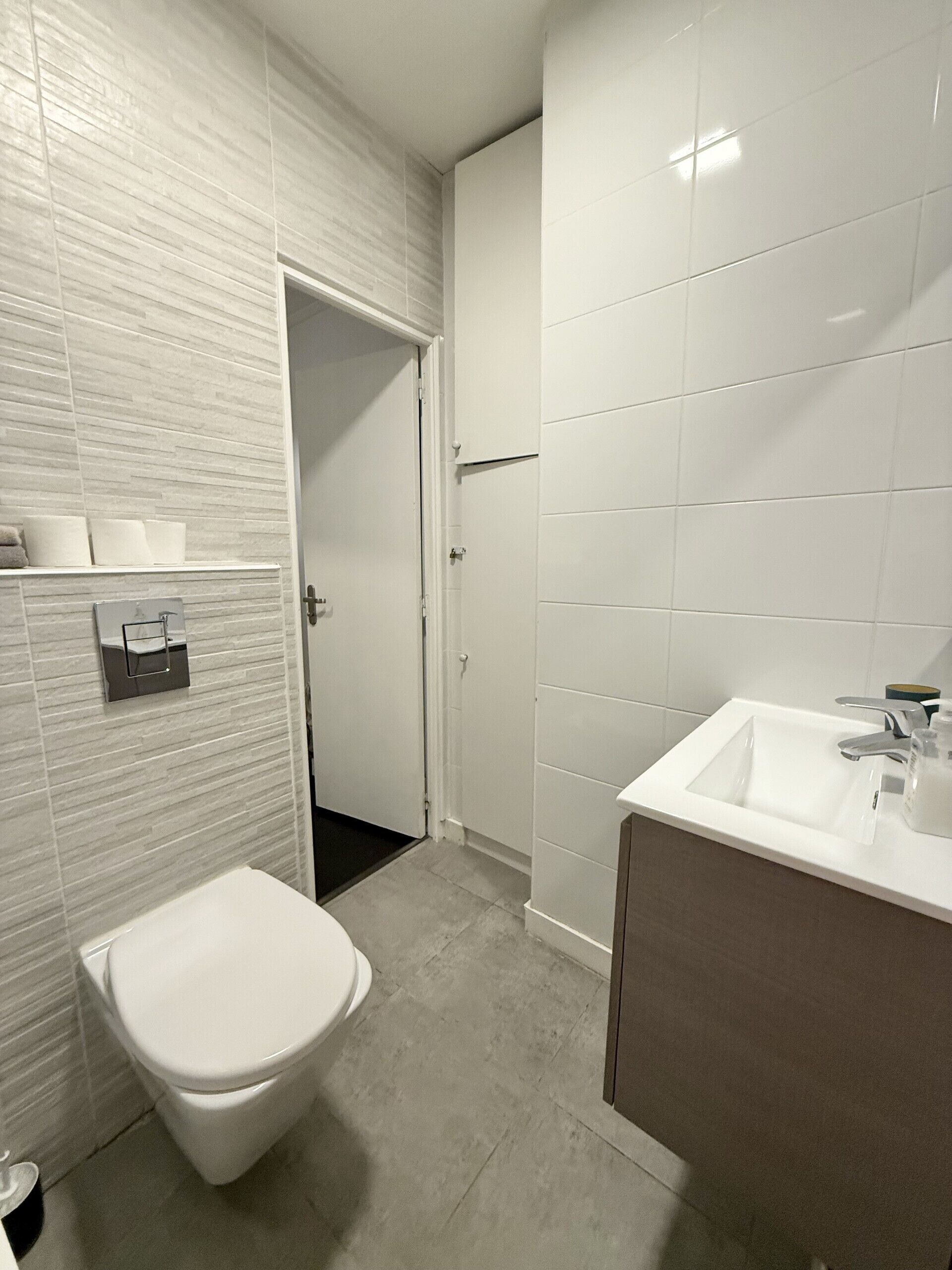 A modern bathroom with a toilet, sink, and a shower area.
