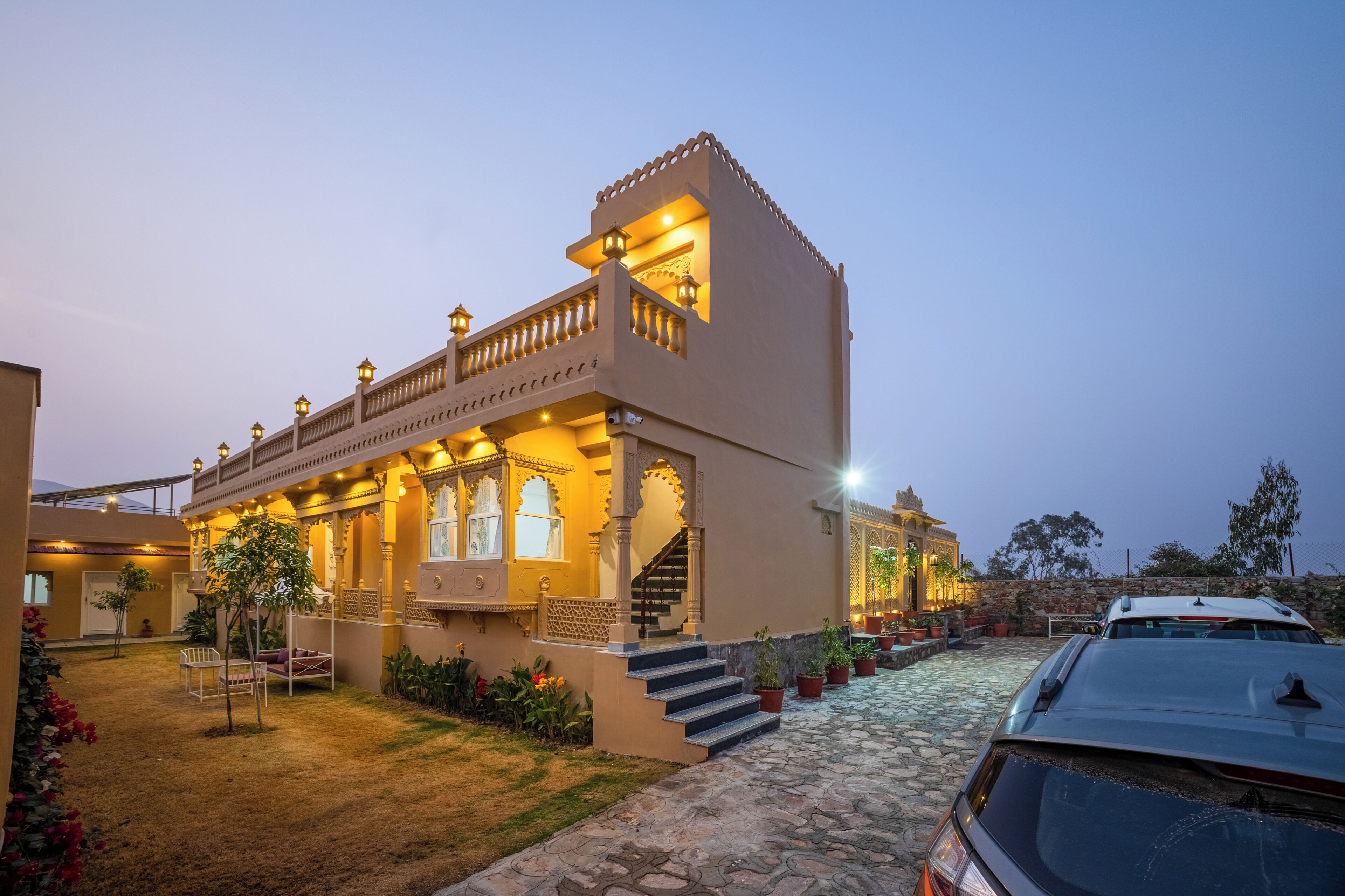 A traditional building with a balcony, steps, and potted plants.