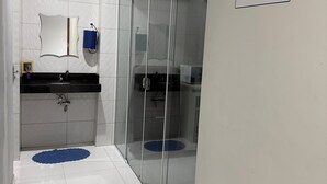 A modern bathroom with a glass shower enclosure, a sink with a black countertop, and a mirror. - Hotel Santa Rita (Amarante do Maranhão)
