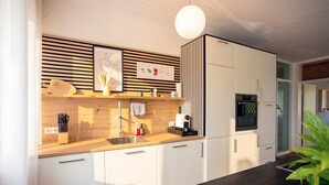 Eine moderne Küche mit weißen Schränken, einer Holz Arbeitsplatte und einer Pendelleuchte.