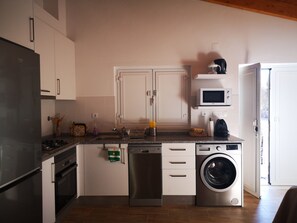 Una cocina compacta equipada con lavavajillas, microondas y lavadora.
