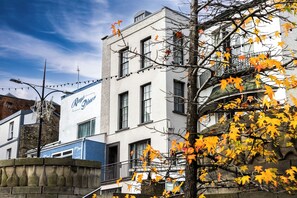 A building with a sign that reads 'Raymond's Diner' and a tree with autumn leaves in the foreground. - Cosy 1BR Flat in Chepstow | Ideal for Work Stays | Sleeps 2 (Monmouthshire)
