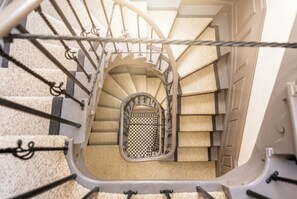 A spiral staircase with a checkered door at the bottom. - Cosy 1BR Flat in Chepstow | Ideal for Work Stays | Sleeps 2 (Monmouthshire)