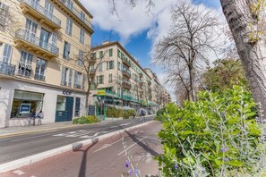 A multi-story building with balconies, a street, and greenery. - GAMBETTA GARDEN AP4507 by Riviera Holiday Homes (Nice)