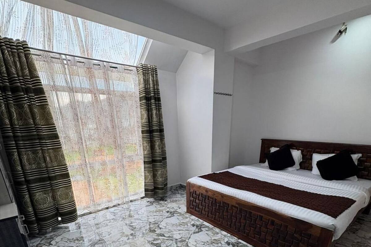 Um quarto com uma cama, uma janela com cortinas e um chão de mármore.