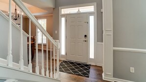 A staircase leading to a door with a white doormat. - Pool is Open! 4BR Retreat • Gameroom • Sleeps 12 (Charlotte)