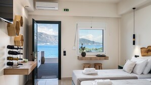 A hotel room with a bed, a window with a view of the sea, a shelf with wine bottles, and a wooden wall decor. - Apovrado Stay by Konnect, Kommeno (Corfu)