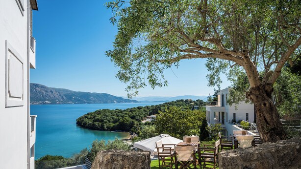 A terrace with a table and chairs, overlooking a lake and mountains. - Apovrado Stay by Konnect, Kommeno (Corfu)