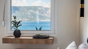 A room with a view of the sea, a window sill with a plant and two cups, and a wooden bench. - Apovrado Stay by Konnect, Kommeno (Corfu)