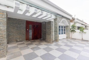 A building with a stone facade, a wooden door, and a checkered floor.