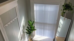 A wooden staircase with white railings, a potted plant, and a window with blinds. - Cozy 1-bedroom apartment with parking in walkable Portland location (Portland)