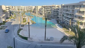 Un complexe hôtelier doté d’une piscine, de palmiers et de bâtiments à plusieurs étages.